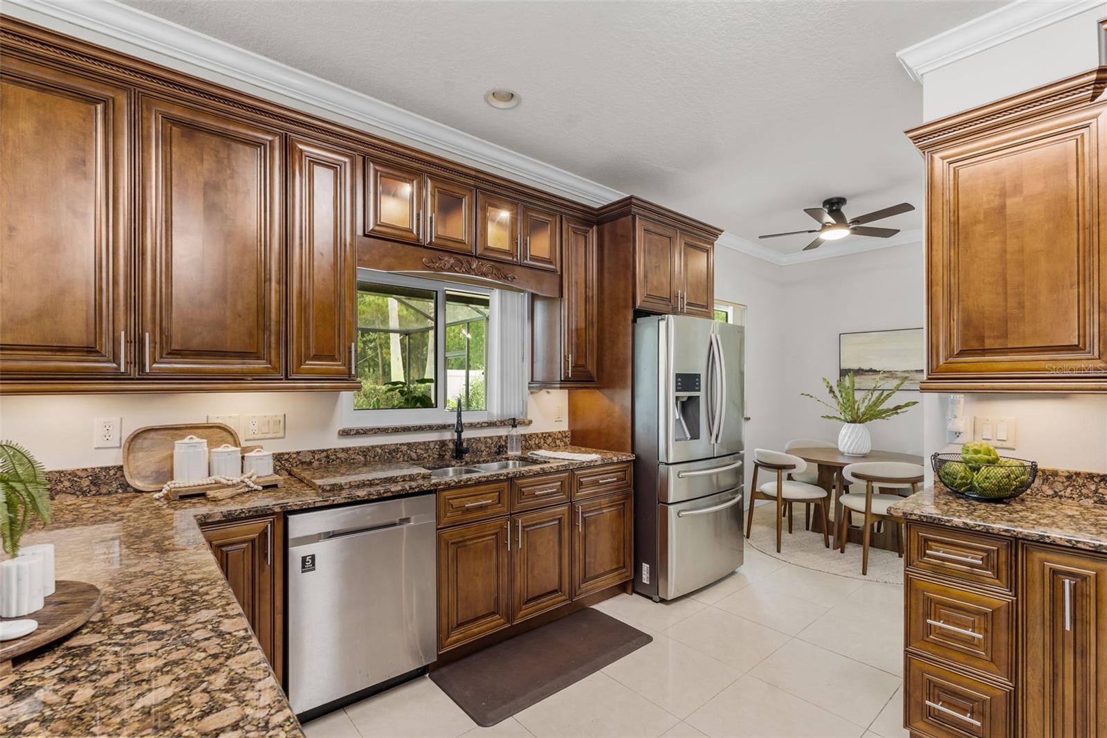 Chef's kitchen with stainless appliances - elegant cabinet detail -under cabinet lighting - glass transoms on cabinets