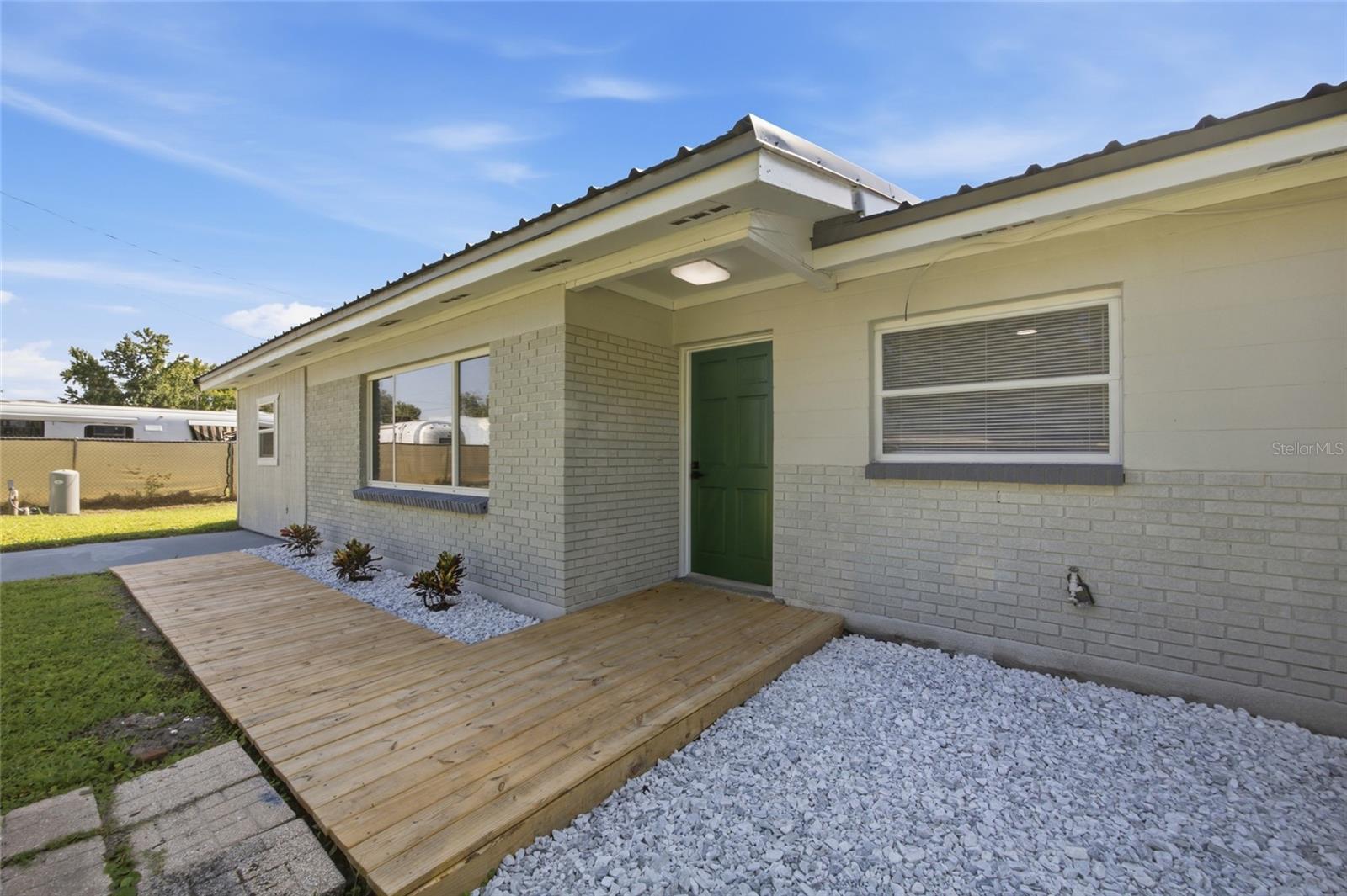 Wood deck leading to door from driveway.