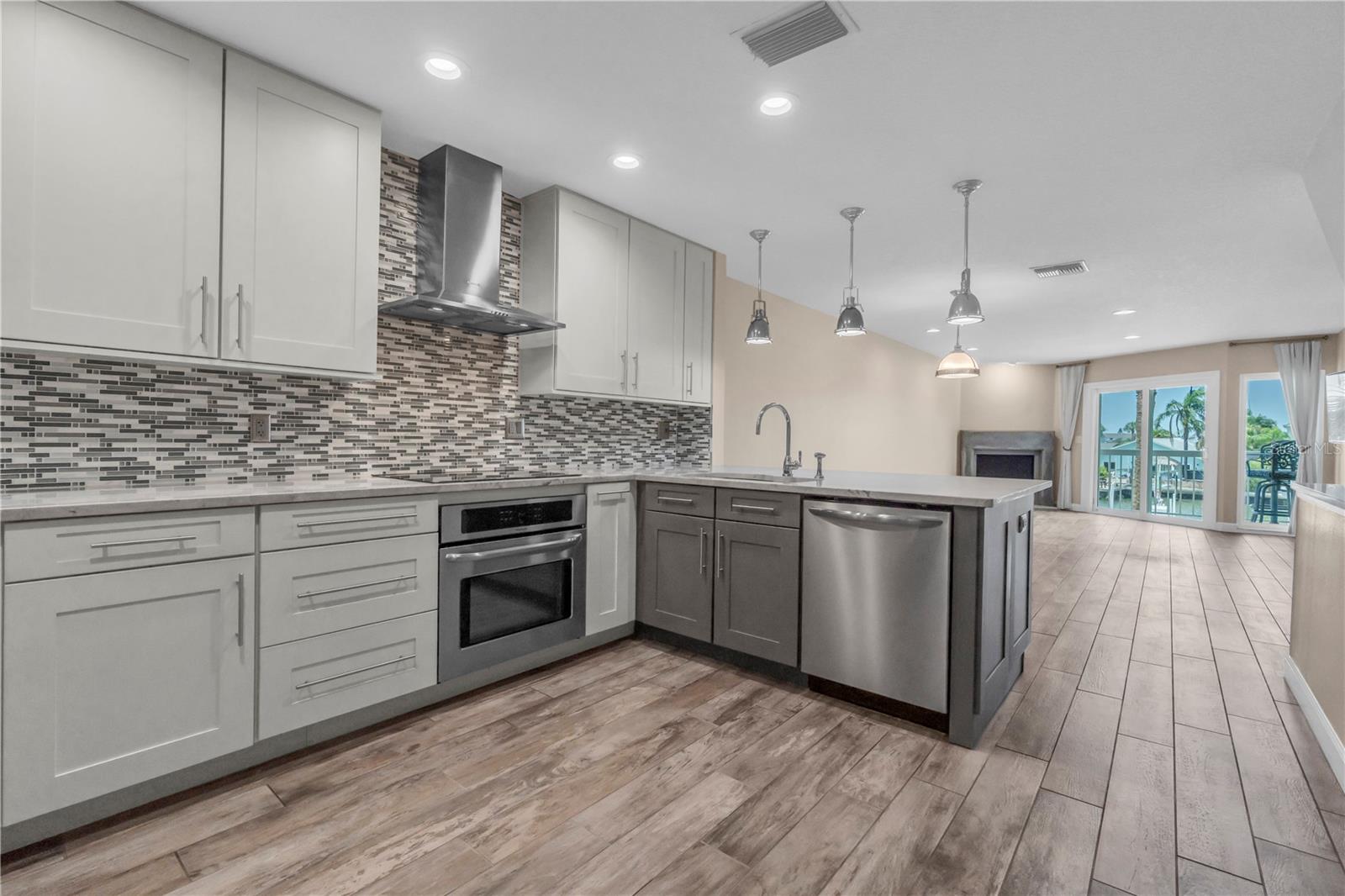 Light pours through this open layout, where the kitchen flows straight into a great room built for gathering. Two-tone cabinetry and clean lines give it a fresh, coastal-contemporary feel.