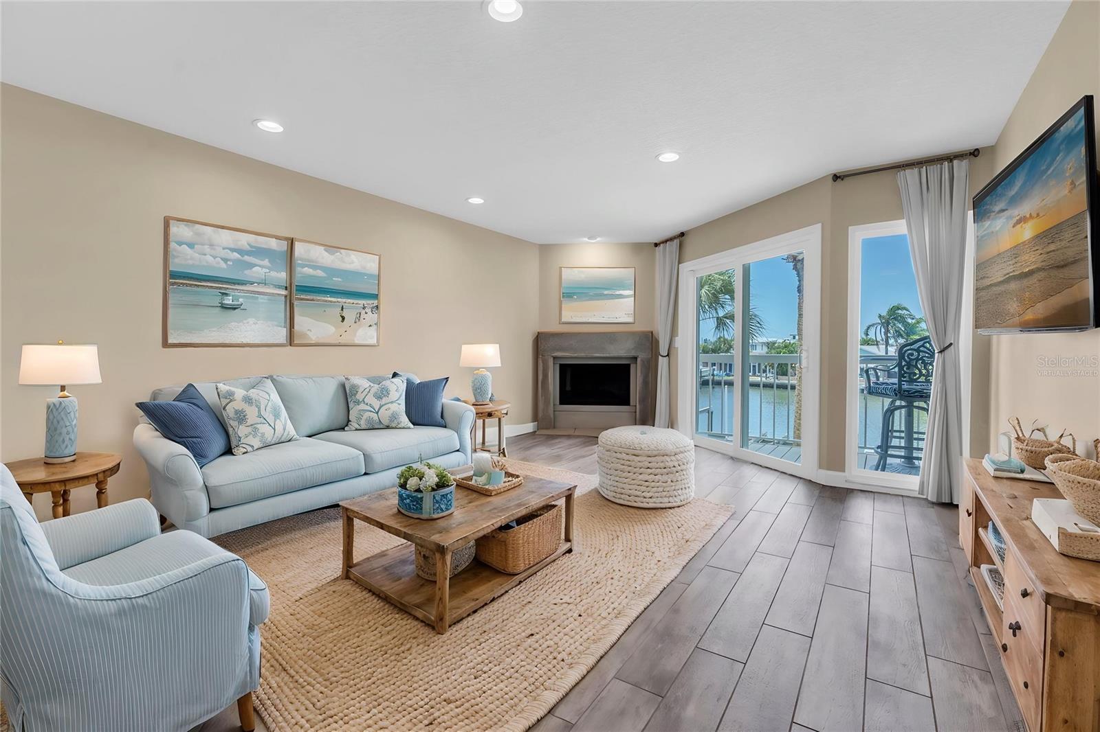 Virtually Staged - Cozy up by the fireplace — or fling open the sliders and let the water view in. This is the room where quiet mornings and lively evenings both feel right at home.