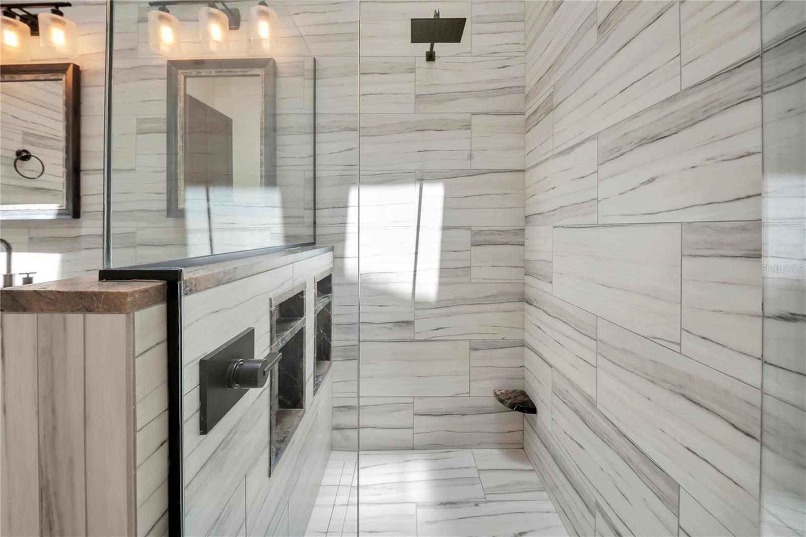 Step into a shower that feels more spa than standard — floor-to-ceiling marble-look tile turns a daily routine into a small daily escape.