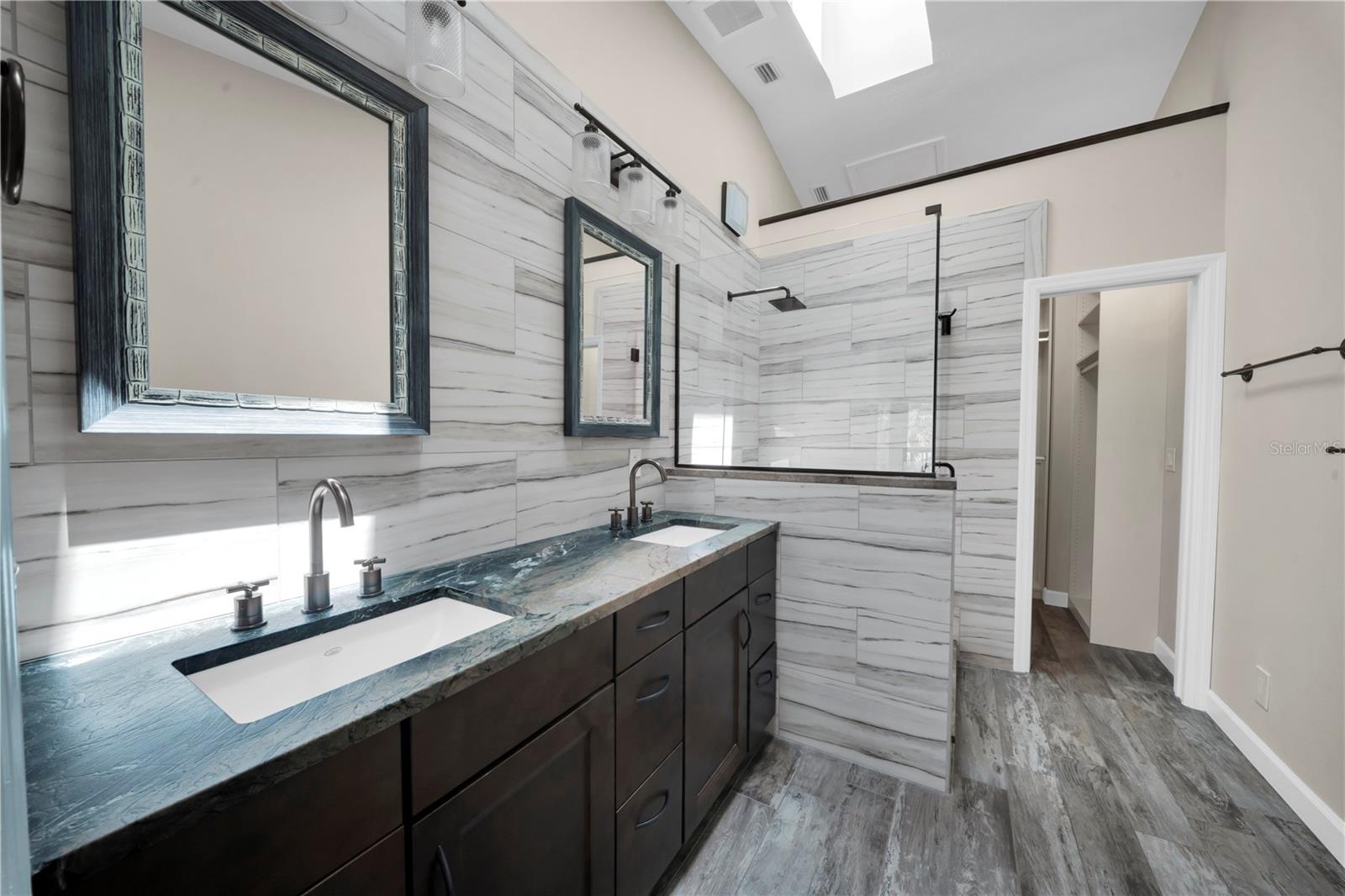 His and hers, done right. Rich stone counters and warm-finished mirrors bring a boutique-hotel feel to the everyday.