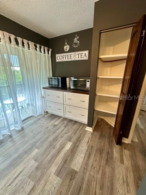 Coffee/Tea bar with exrea cabinetry, microwave and air fryer