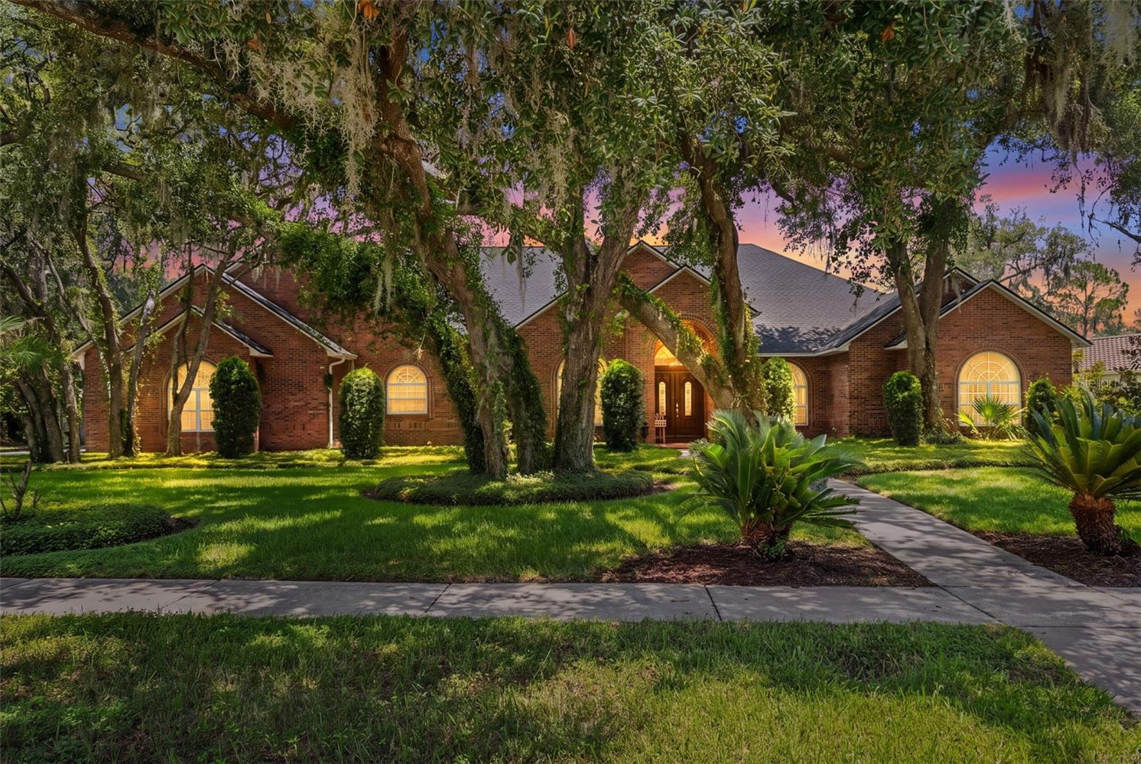 As evening settles in, the home's warm glow hints at the elegance, comfort, and memorable moments waiting within.