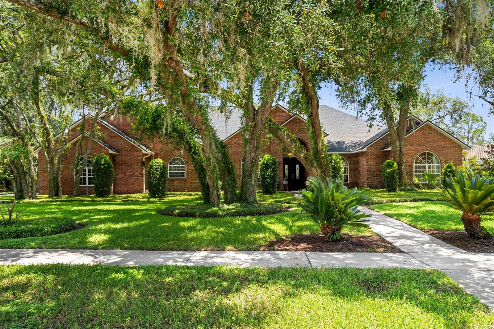 Gracefully set beneath a canopy of mature oaks, this custom residence makes an unforgettable first impression long before you reach the front door.