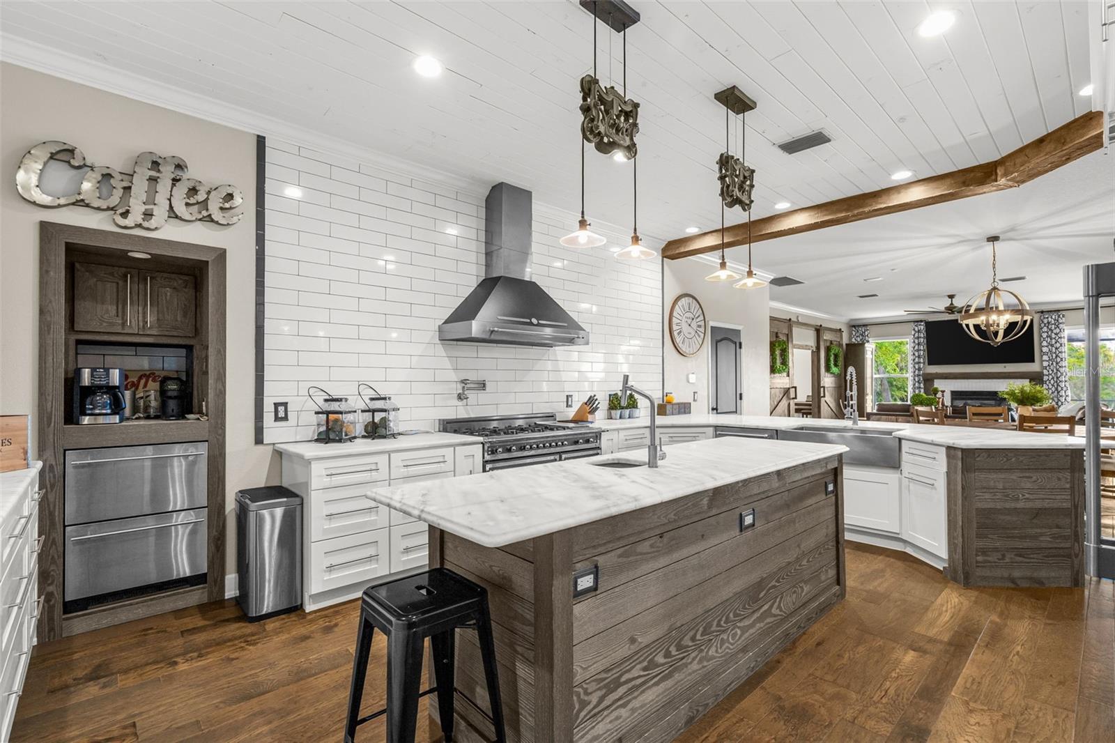 Expansive quartz countertops, custom cabinetry, and premium appliances create a workspace as beautiful as it is functional.