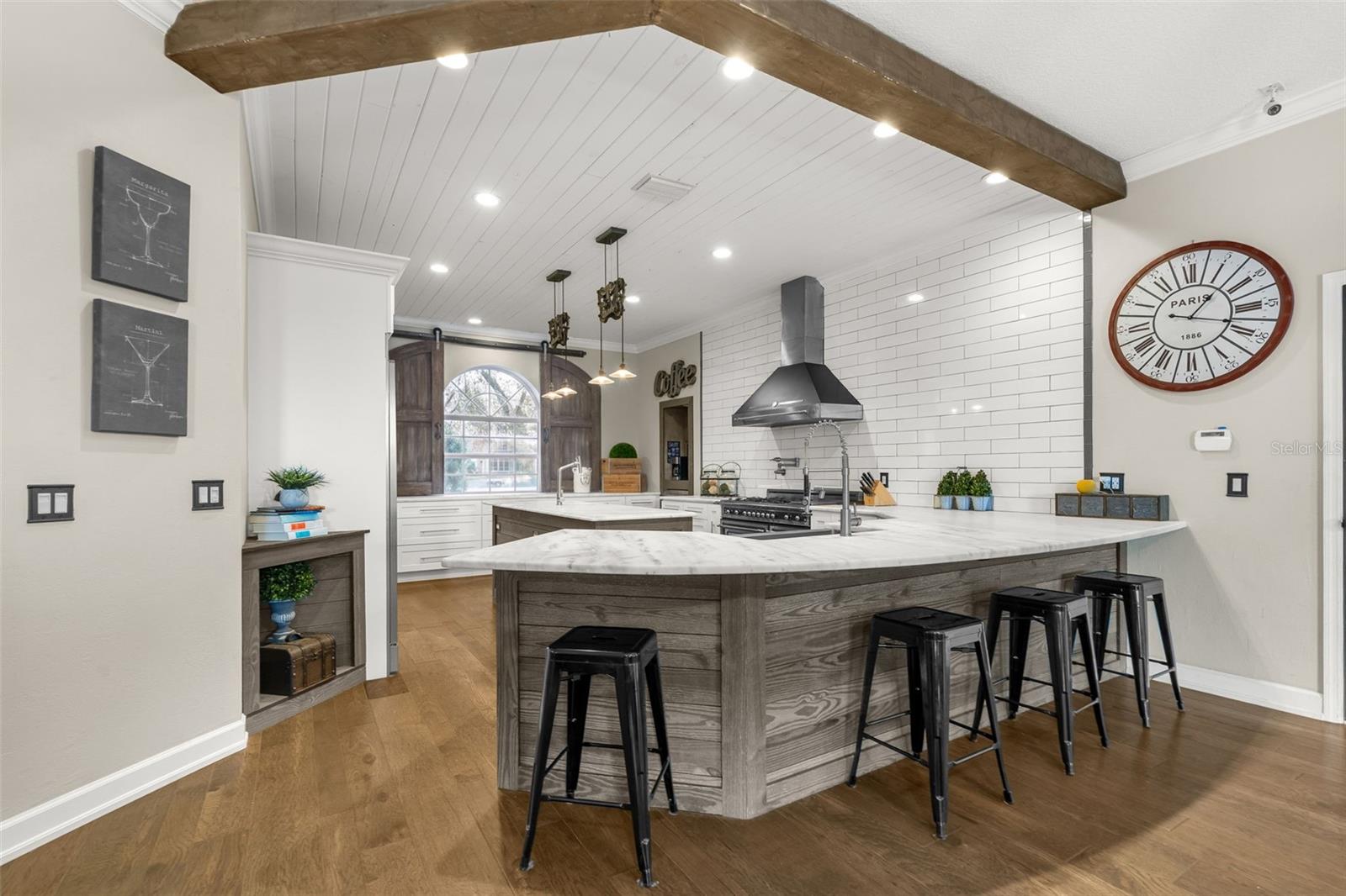 At the center of it all, the oversized island invites conversation, casual dining, and the moments that make a house feel like home.