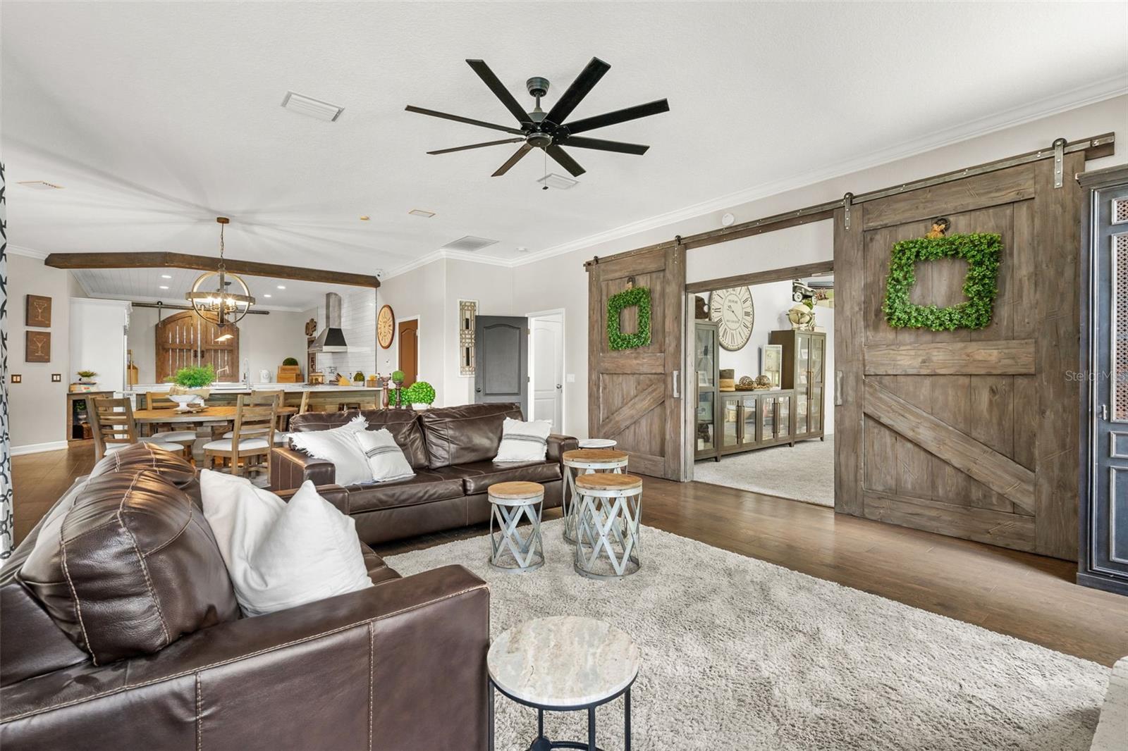Custom barn doors reveal a versatile bonus room, offering endless possibilities as a media room, home office, playroom, fitness space, or additional bedroom.