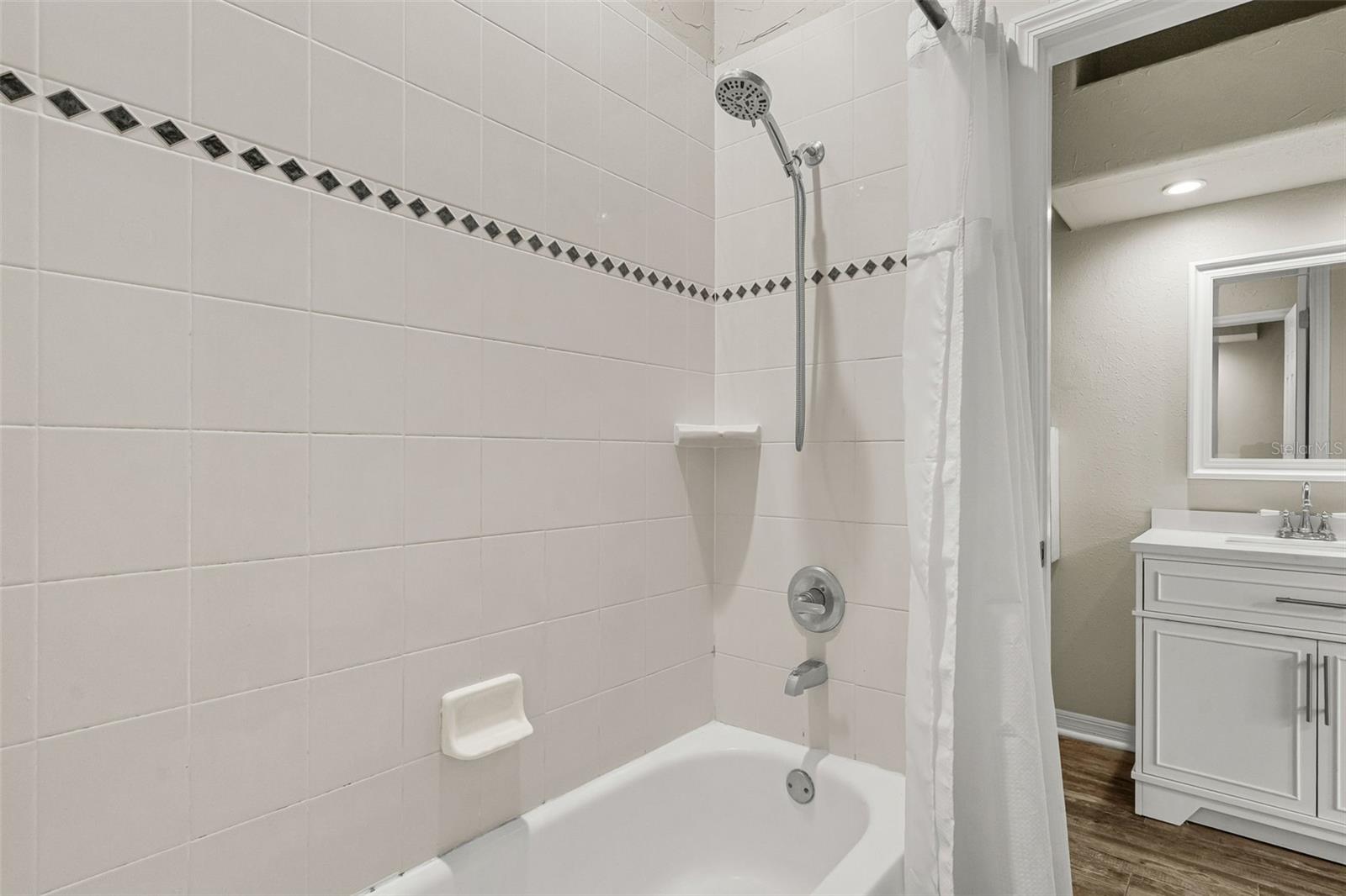The shared shower is thoughtfully positioned between Bedrooms 2 and 3, providing convenient access while maintaining each bedroom's private vanity and water closet.