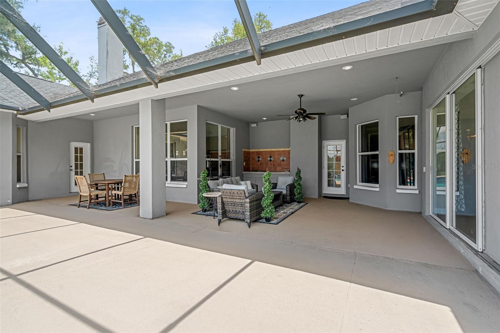 Multiple French doors create a seamless connection between the home's elegant interior and its inviting outdoor living spaces.