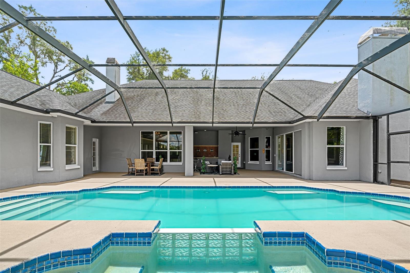 The elevated spa offers the perfect place to unwind while overlooking the pool and peaceful backyard beyond.