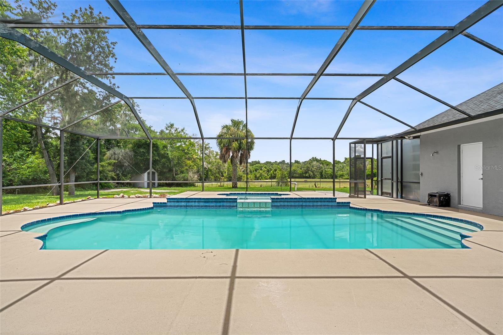 Surrounded by peaceful views and a spacious screened enclosure, the pool offers a private escape to enjoy Florida living year-round.