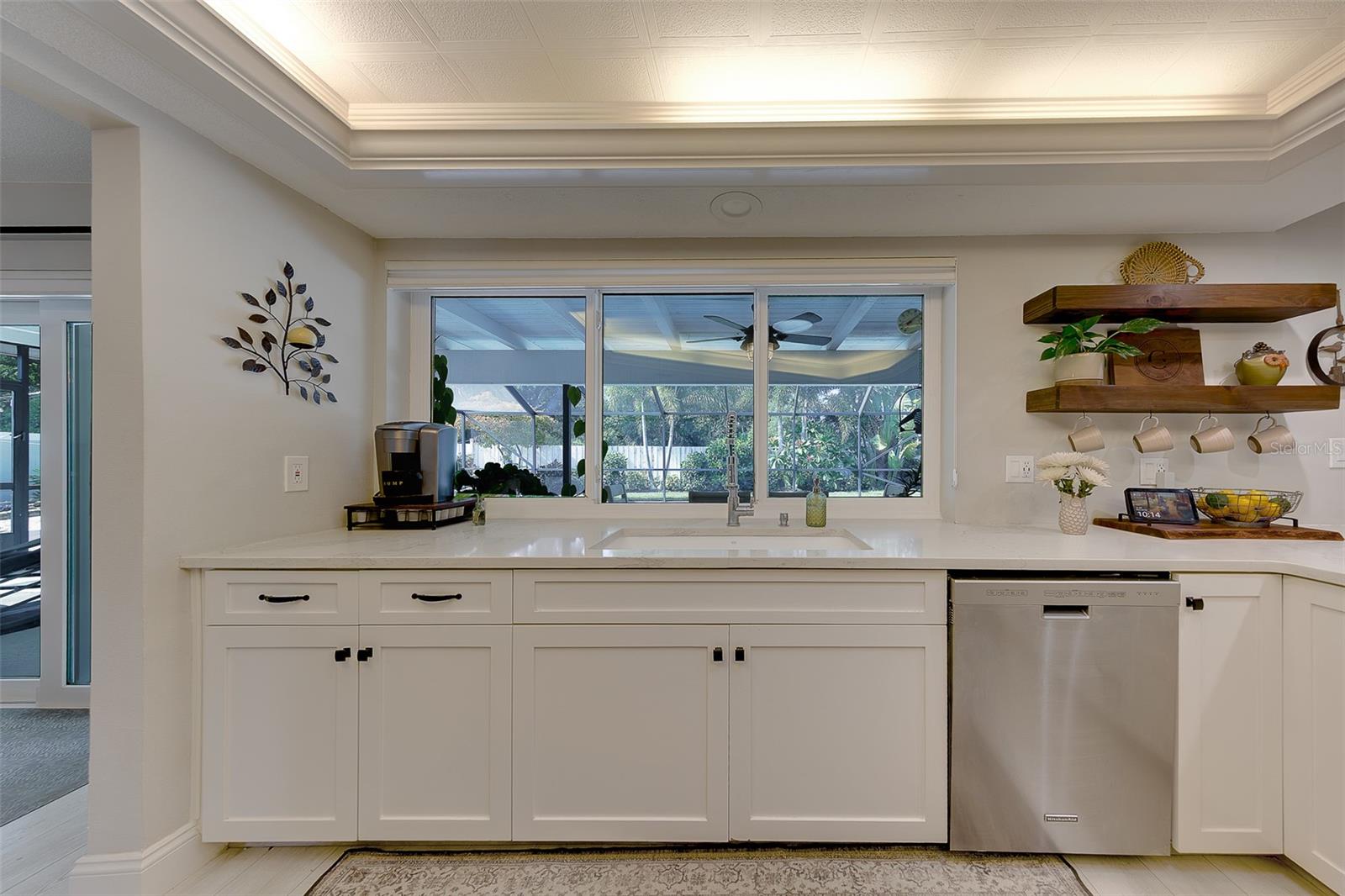 Bright and beautiful kitchen with windows that open up to the pool