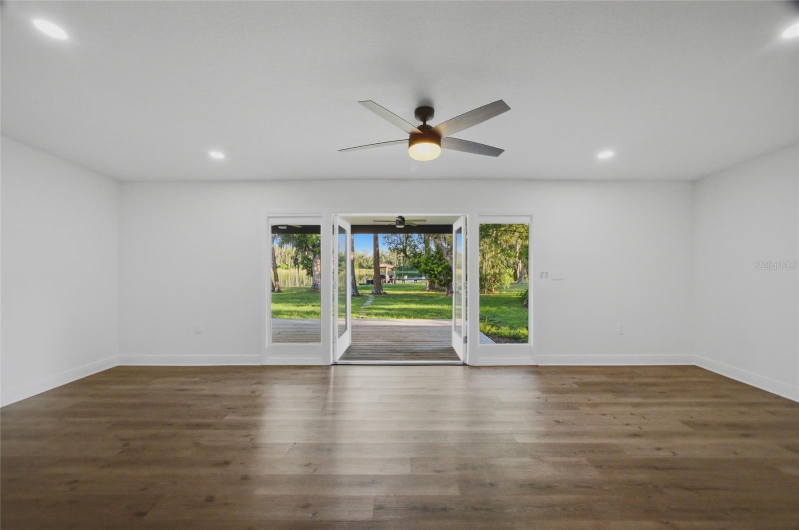 doors open to the covered back porch with steps to the lake