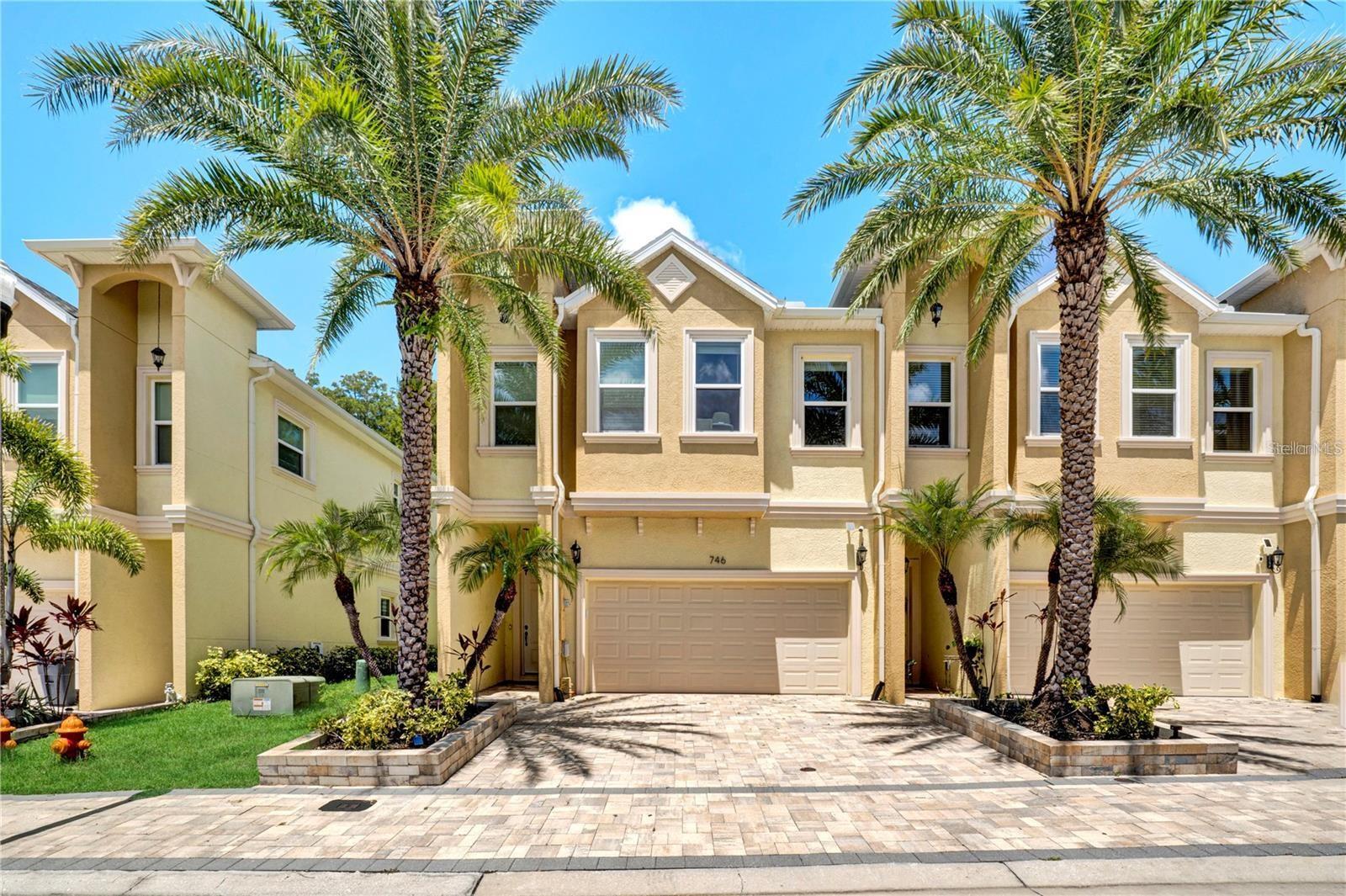 Welcome home! This stunning, modern townhouse boasts exceptional curb appeal with a paved driveway, a spacious two-car garage, and beautiful tropical palm landscaping
