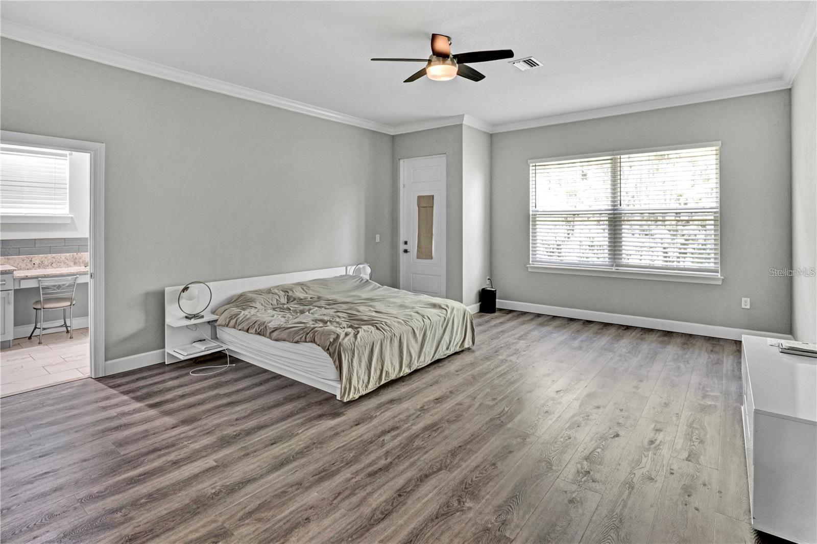 The oversized primary suite offers a serene retreat with ample space for a king-sized bed, featuring a private entrance and direct access to the en-suite bath