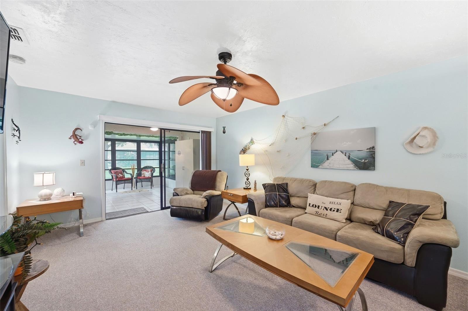 Living Room sliding glass door open to a large Florida Room and Laundry Closet.