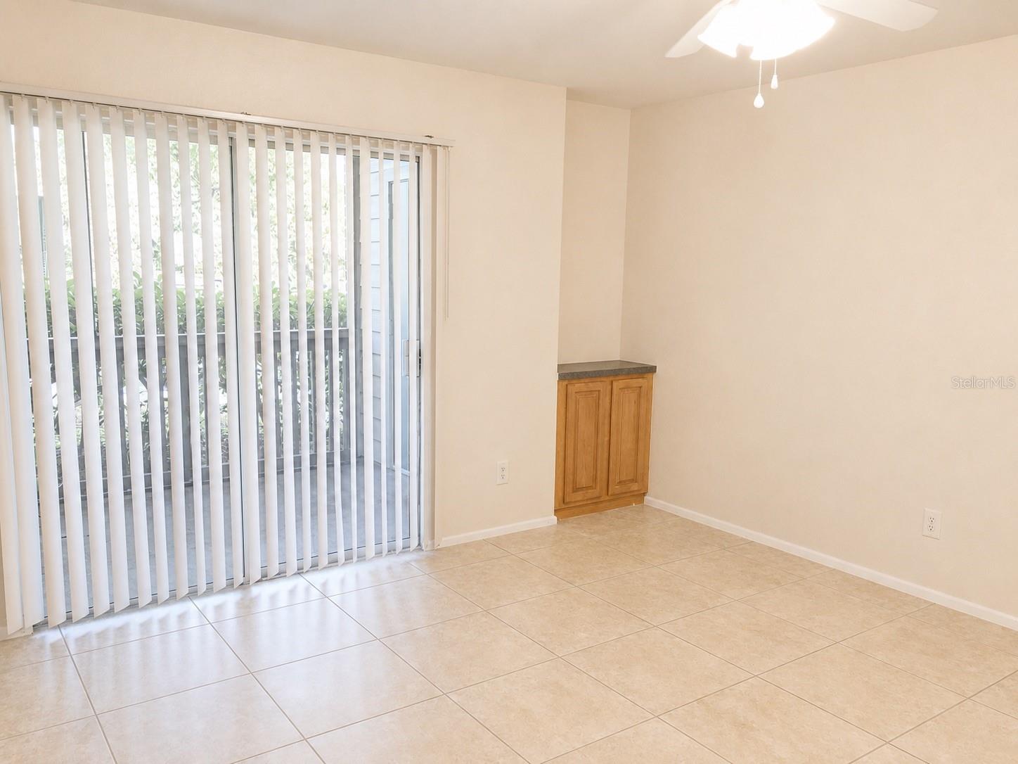 Living area with built-in cabinetry and sliders to the screened patio.