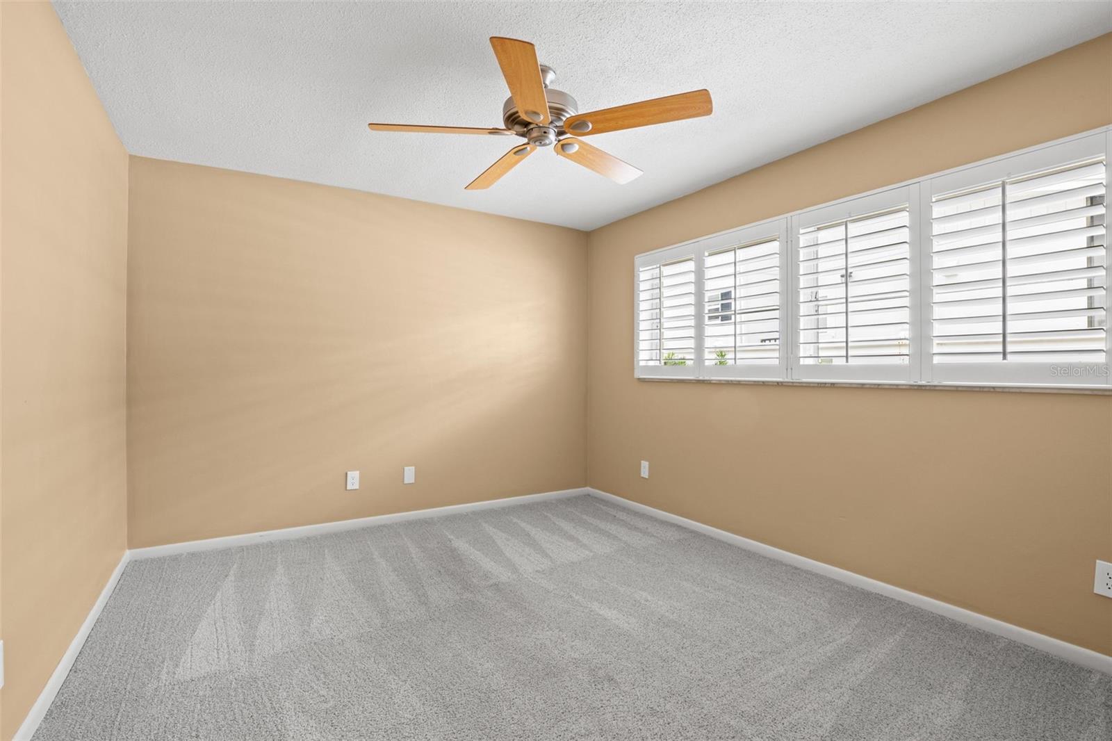 Bedroom 3 - ceiling fan, walk-in closet, and plantation shutters
