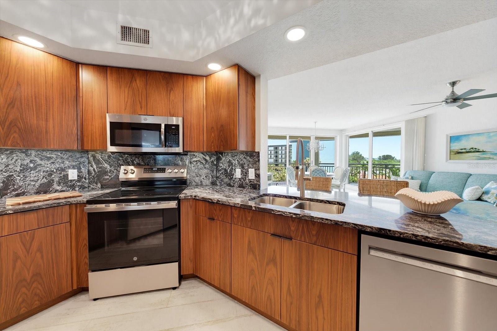 Newer appliances including a brand new stove & oven in roomy galley kitchen with breakfast bar for additional dining space.