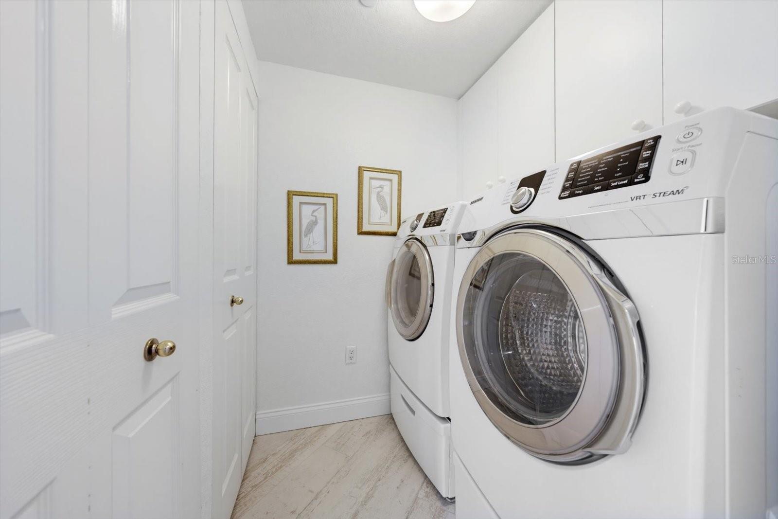 Laundry room offering oversized washer & dryer.