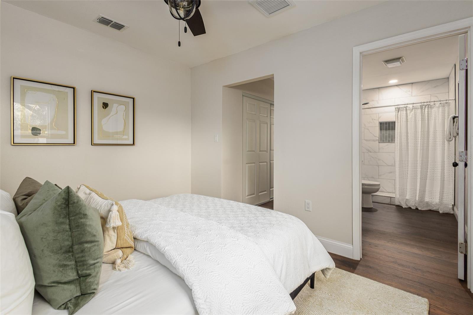 Main bedroom with en -suite bathroom previously staged with a queen bed and night tables