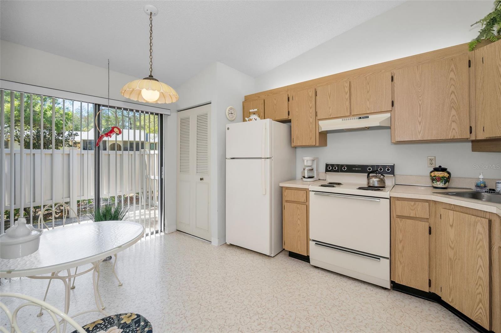 Kitchen With Laundry Closet, Eating Space, and Slider To The Front Patio