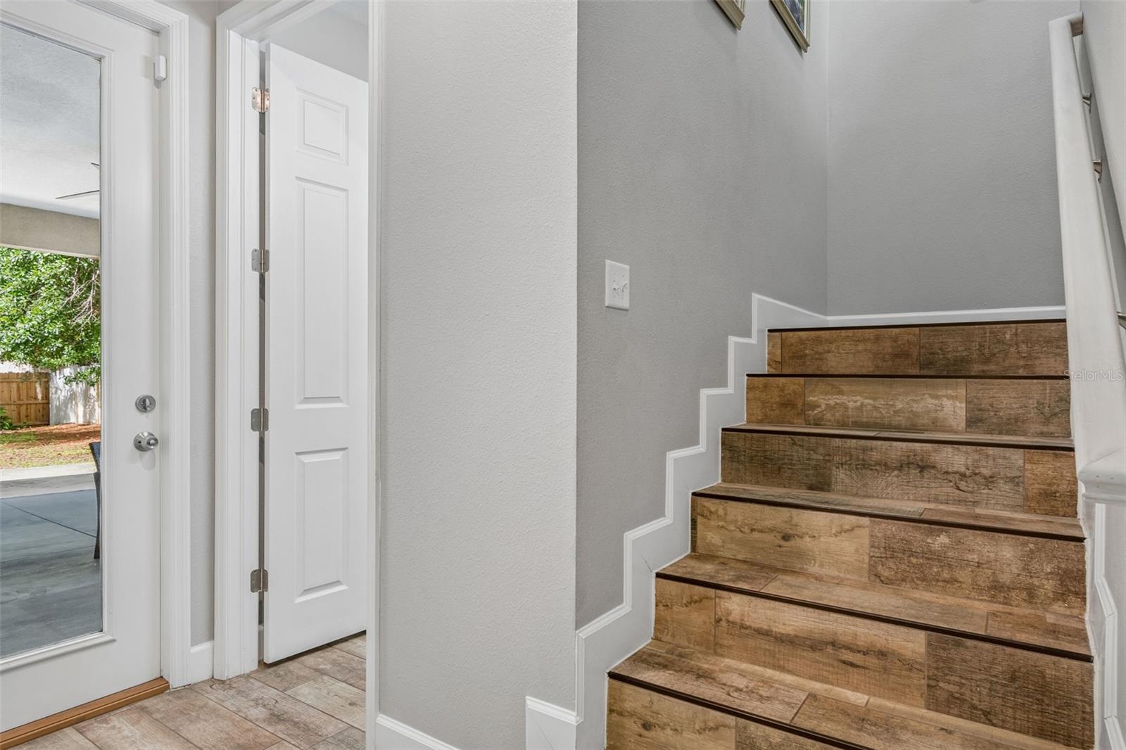 Door to covered patio, entrance to full bath and staircase to second floor