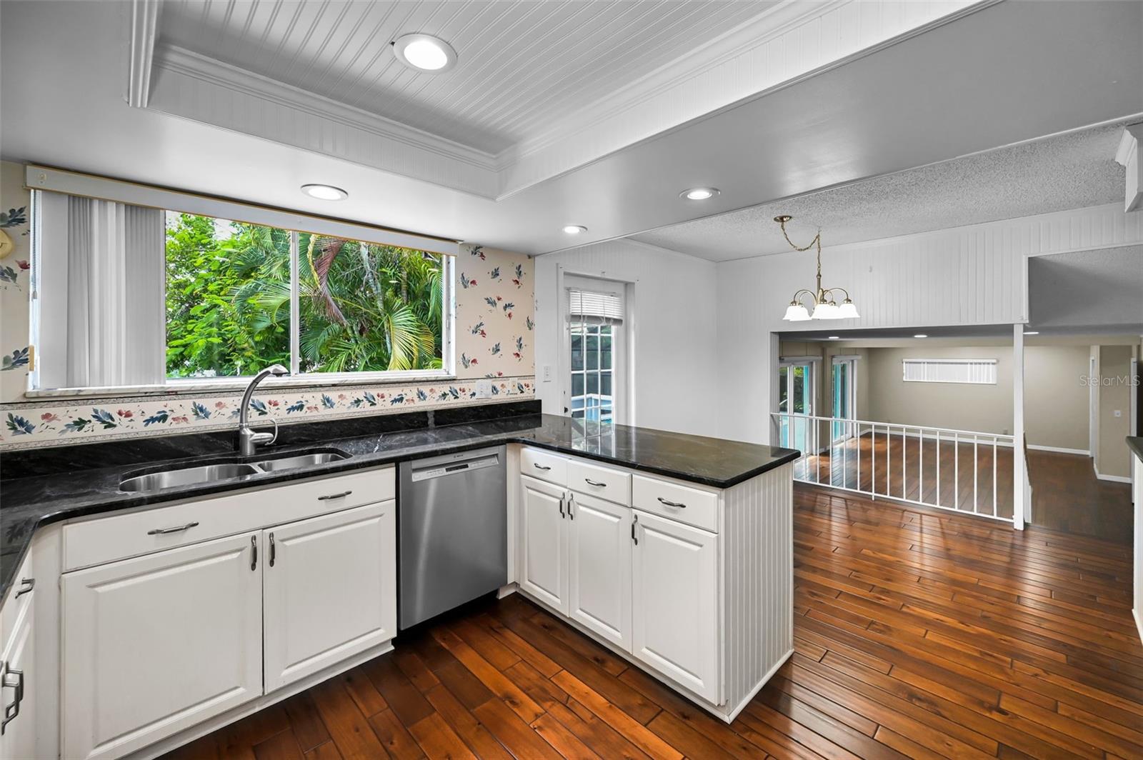 A contemporary kitchen with crisp shaker cabinetry overlooking both the dining area and family room