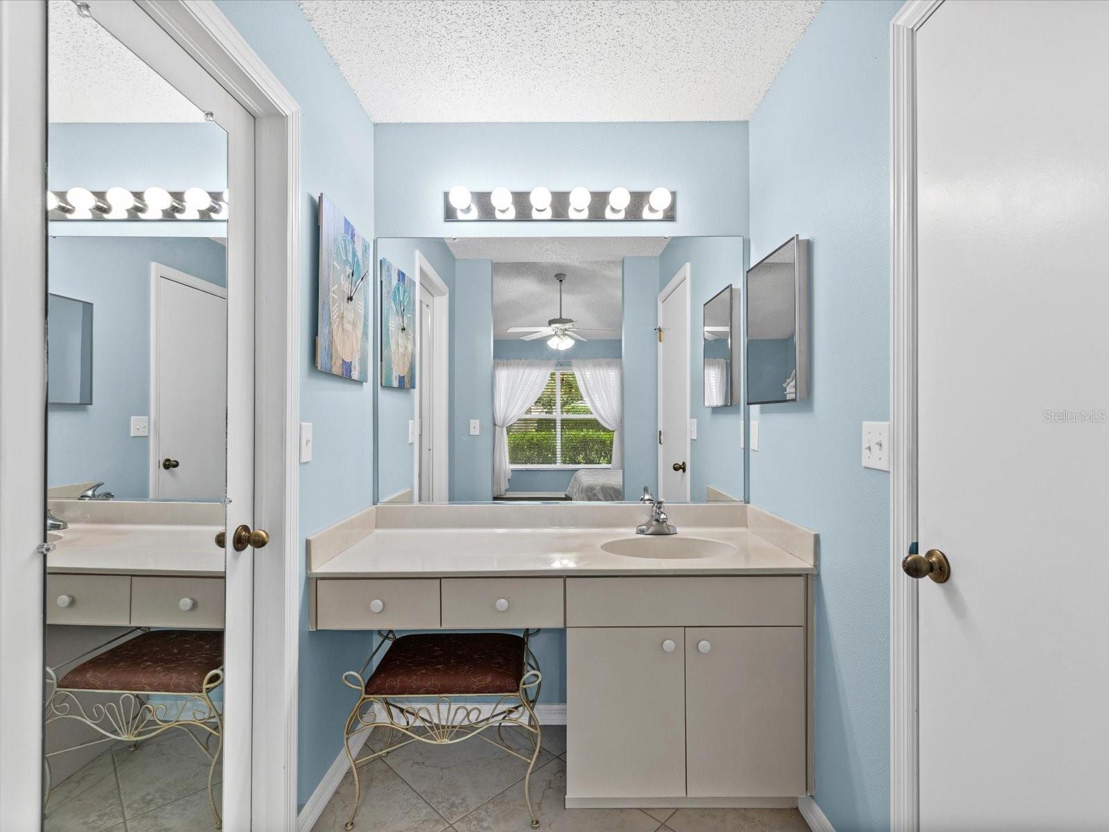 Vanity area of Primary Bathroom. Large walkin closet on left
