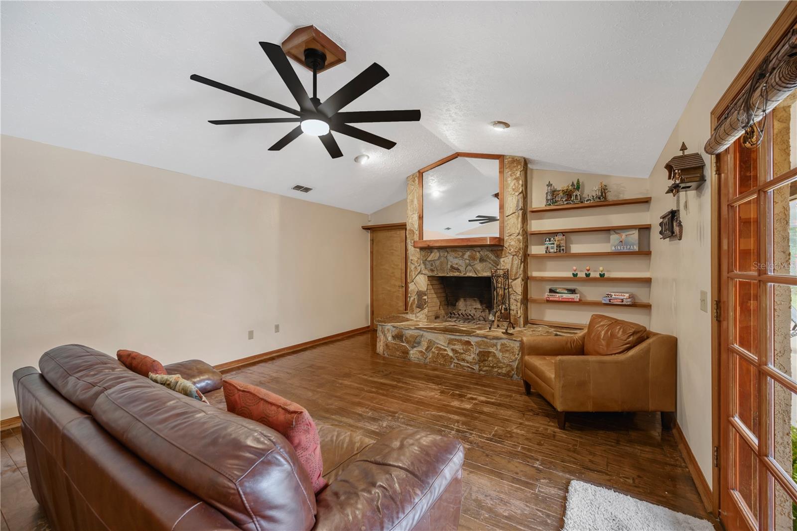 The family room has cathedral ceiling, wood floors and a stone wood burning fireplace.