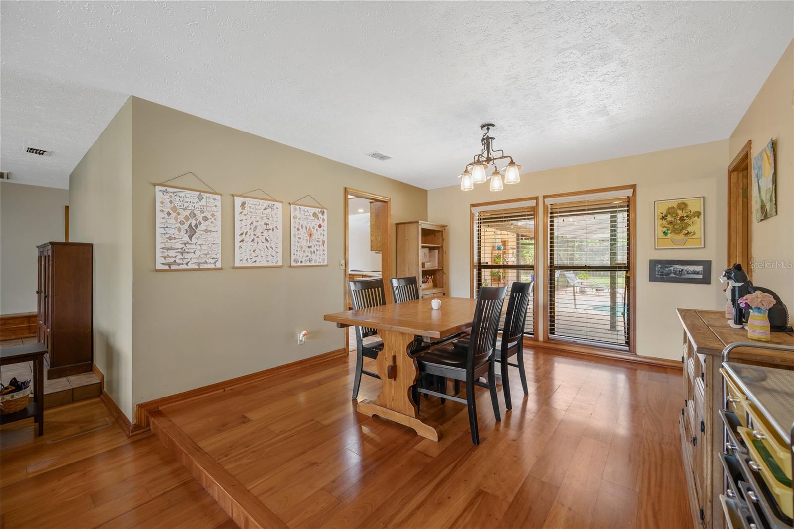 There are floor to ceiling windows in the dining room overlooking the back porch and pool.