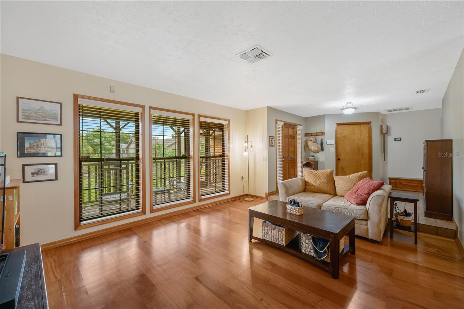 The living room with gorgeous wood floors looks into the front yard.