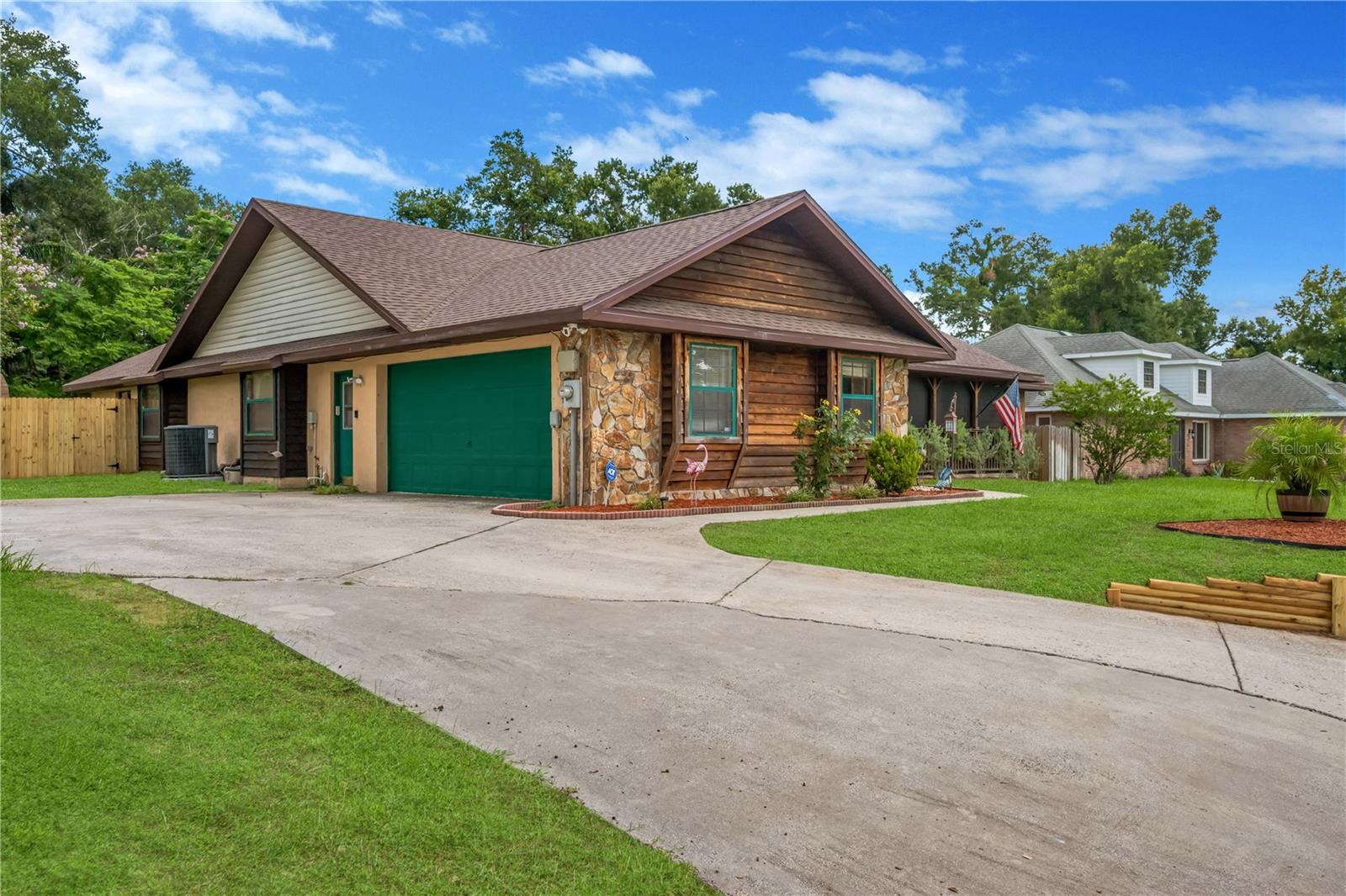 Oversized 2-car side entry garage with large driveway and parking pad.