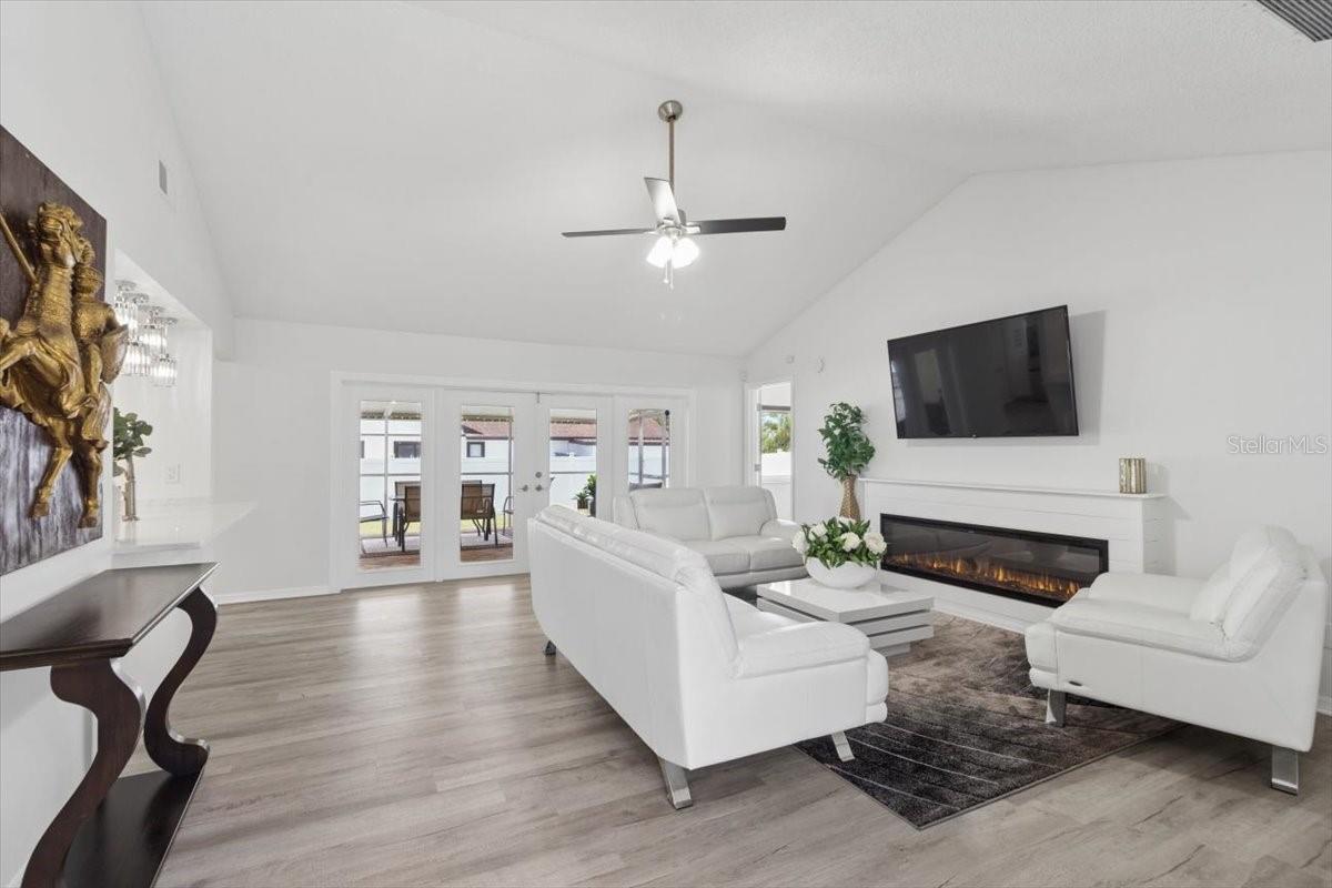 Designed for both comfort and entertaining, the spacious living room showcases elegant French doors leading to the backyard and a stylish faux fireplace that adds charm and ambiance.
