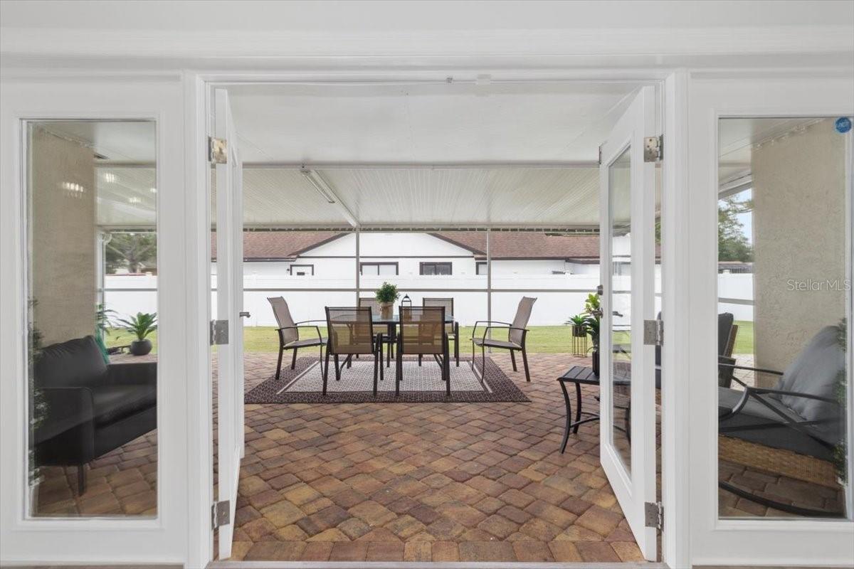 The French doors invite you to a fully enclosed paver patio, offering a versatile space for entertaining, dining, or simply enjoying the Florida lifestyle.
