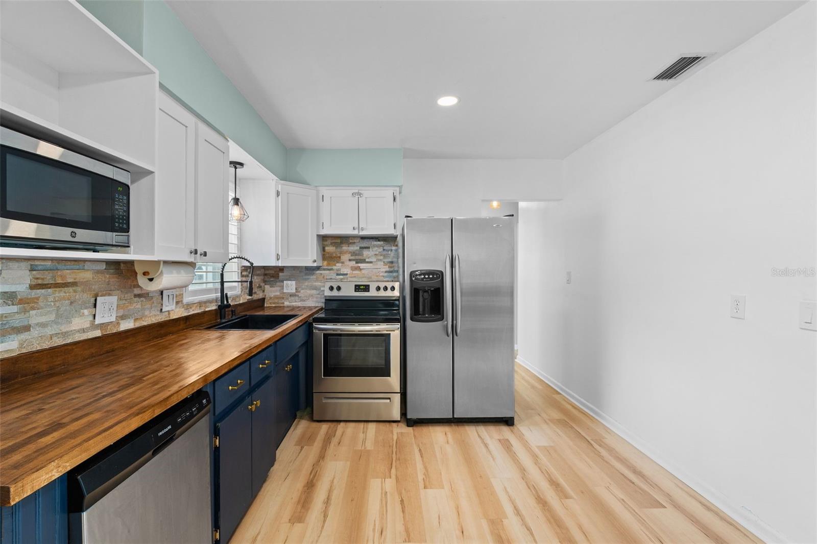 large kitchen overlooking back yard living area including pool.
