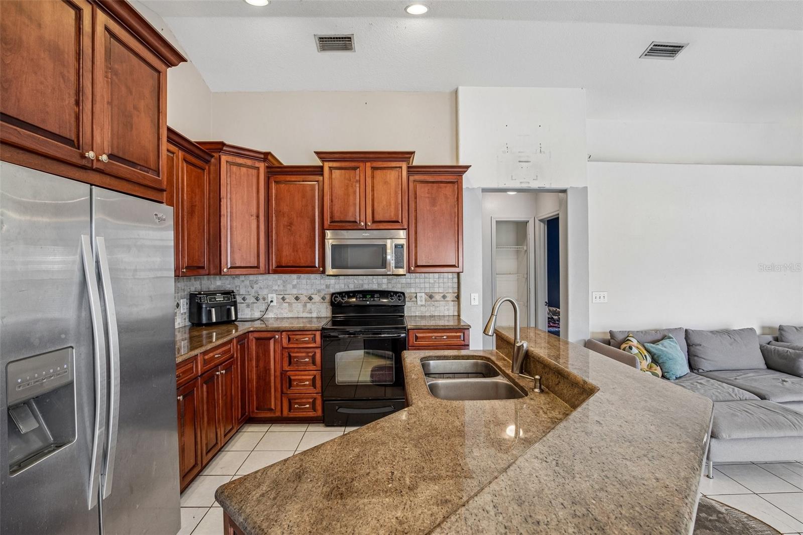 KITCHEN WITH HIGH BAR ALLOWS FOR EXTRA SEATING