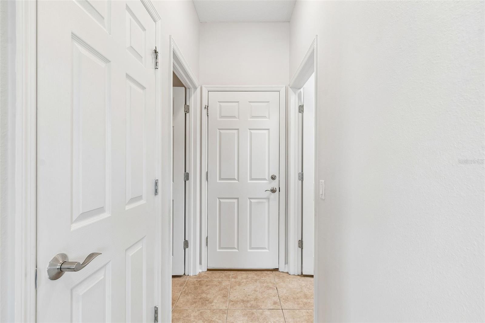 hallway leading to half bath/laundry room/garage