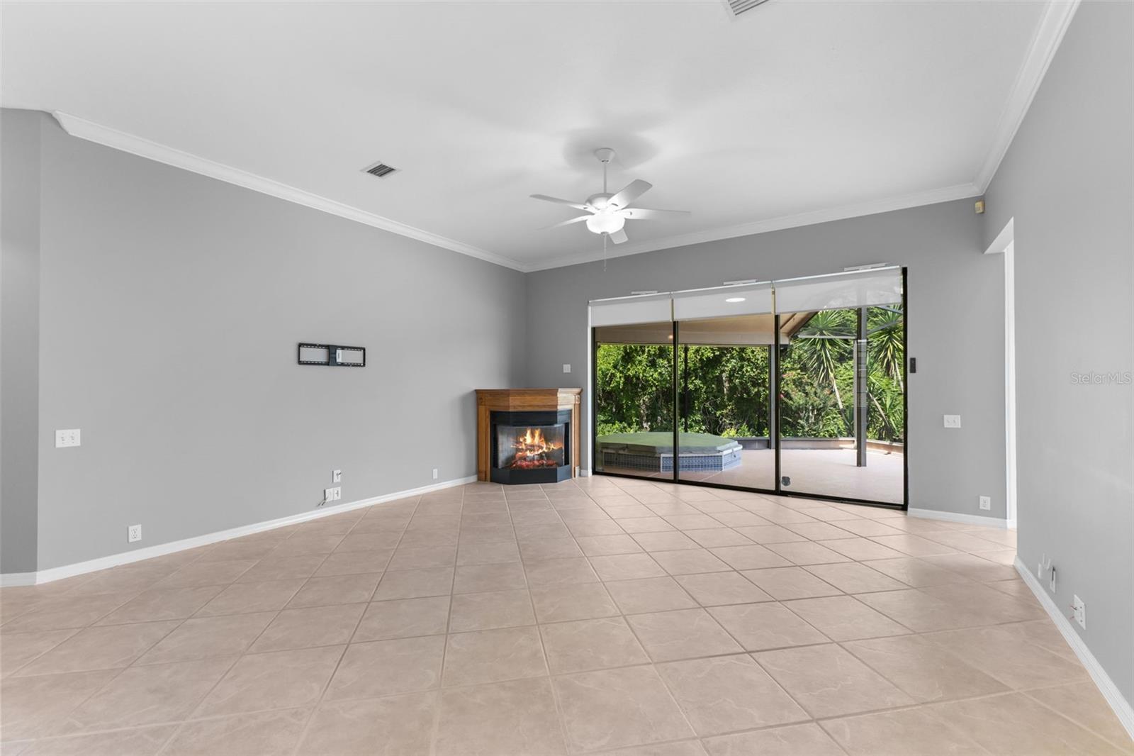 Spacious great room featuring high ceilings, neutral tile flooring, and an open layout designed for comfortable everyday living and entertaining.