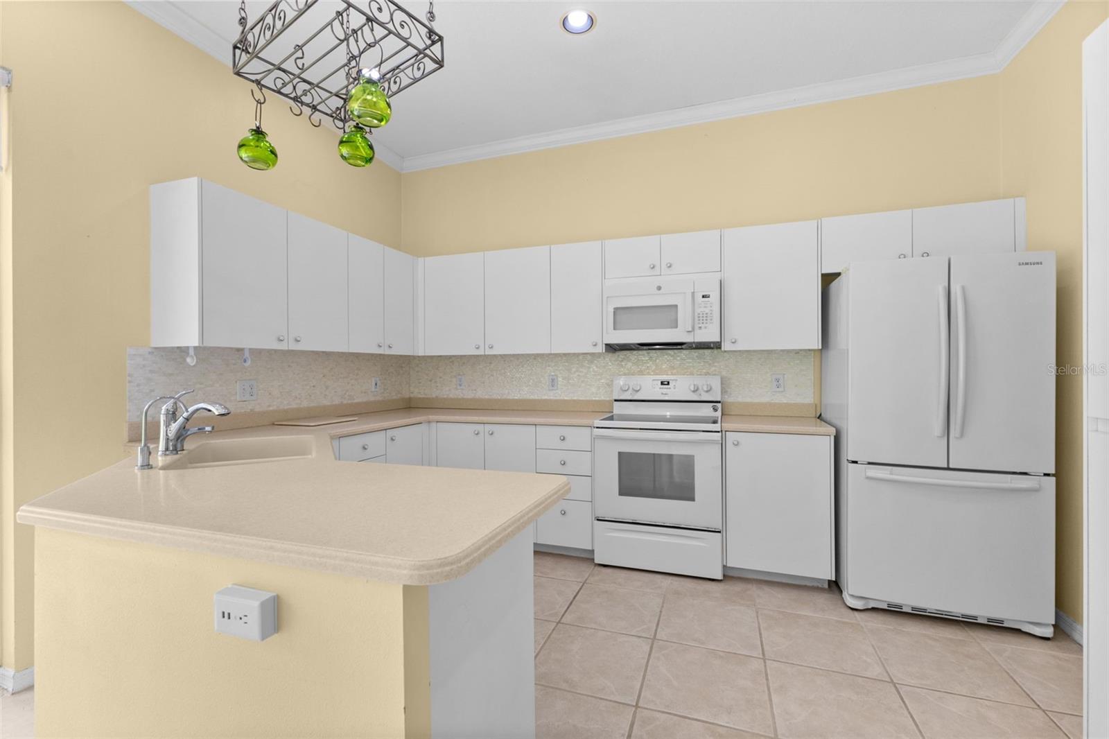 Well-maintained kitchen with generous cabinet space, breakfast bar, and an eat-in dining area overlooking the private backyard.