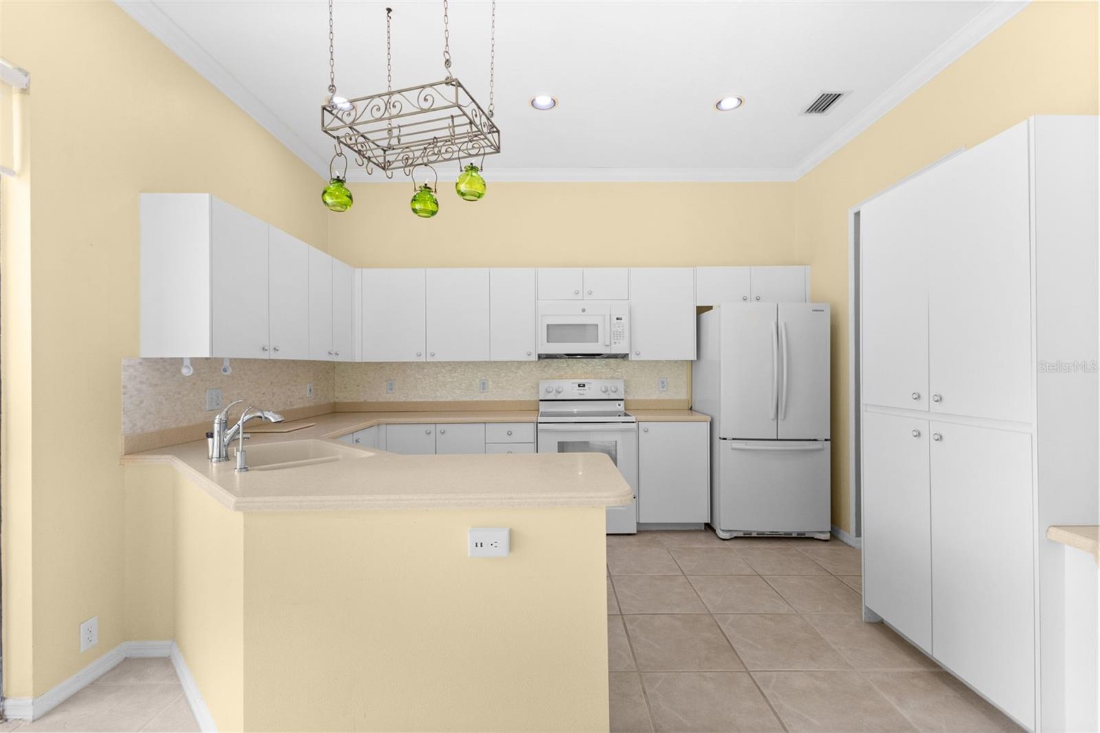 Well-maintained kitchen with generous cabinet space, breakfast bar, and an eat-in dining area overlooking the private backyard.