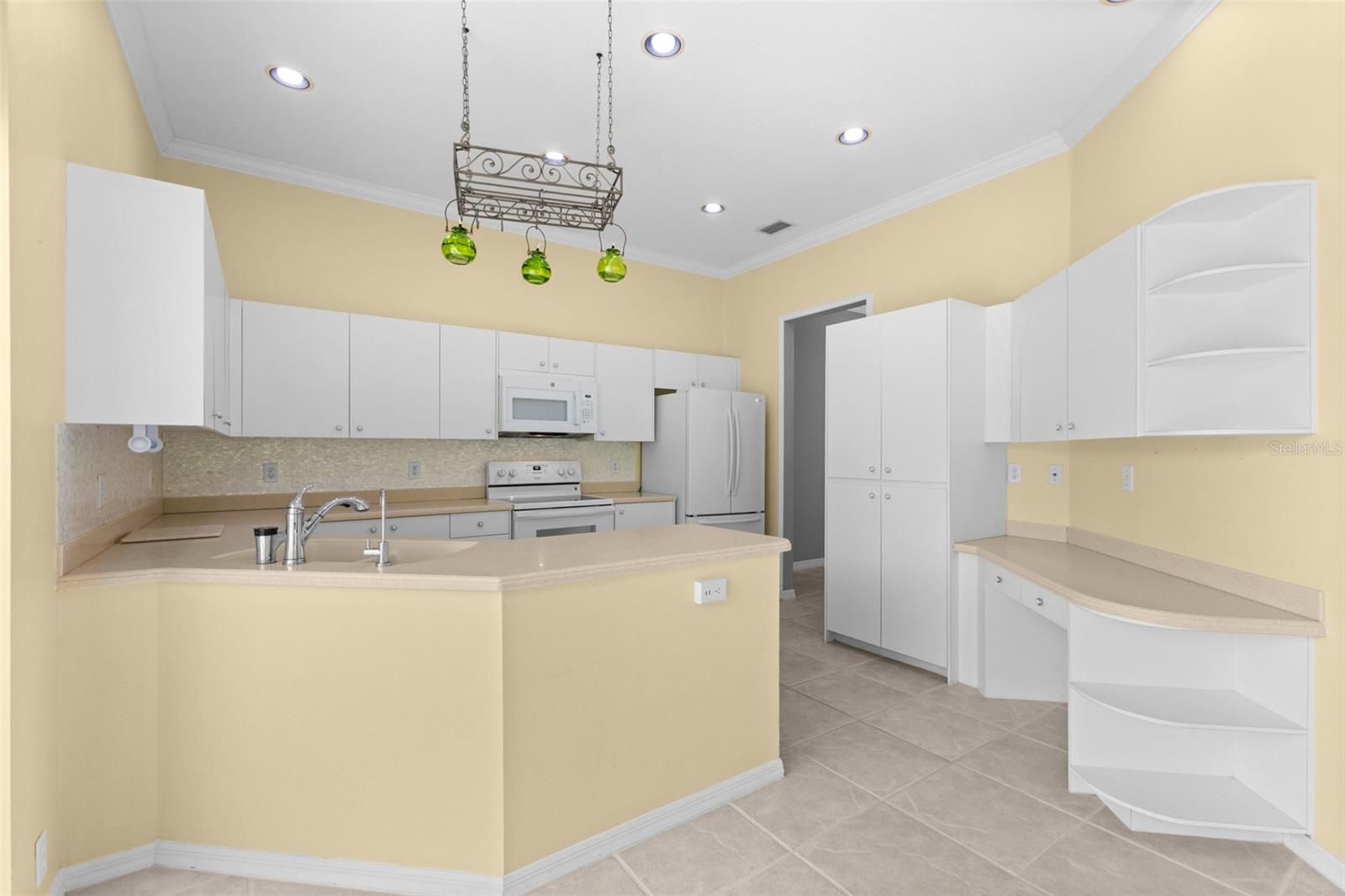 Well-maintained kitchen with generous cabinet space, breakfast bar, and an eat-in dining area overlooking the private backyard.