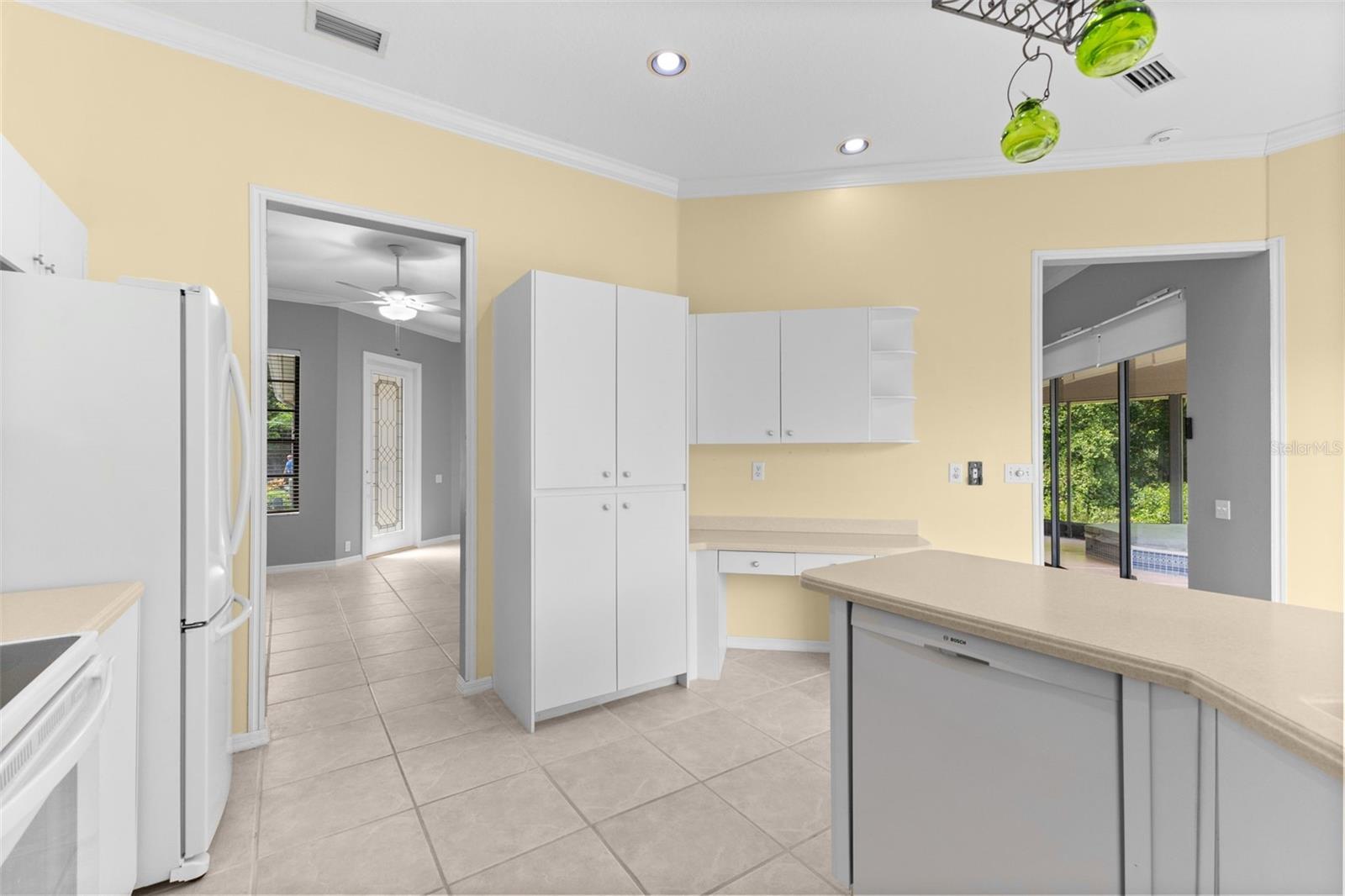 Well-maintained kitchen with generous cabinet space, breakfast bar, and an eat-in dining area overlooking the private backyard.