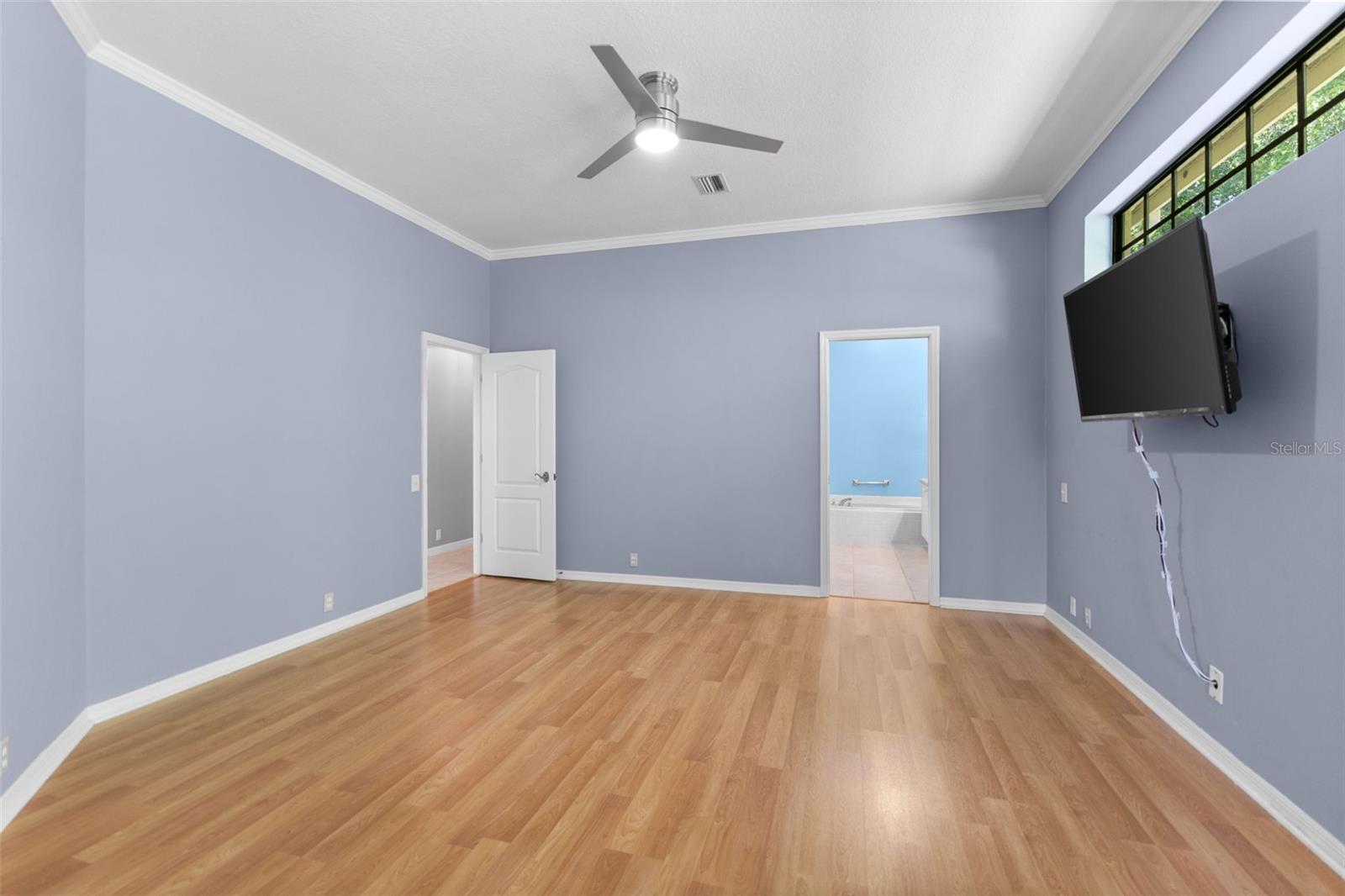 Spacious owner's suite with large windows framing peaceful nature views and plenty of room for a king-size bedroom set.