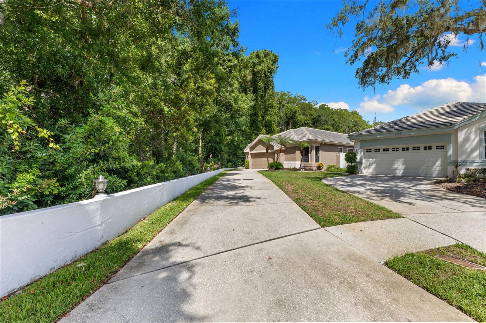 A long driveway and private setting surrounded by lush conservation create a peaceful entrance that is rarely found in maintenance-free communities.