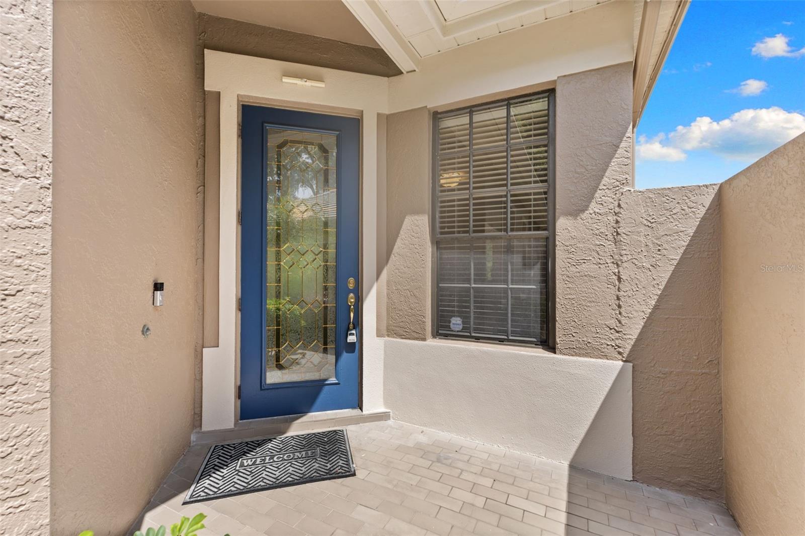 Covered front entry welcomes guests into a bright, open floor plan with soaring ceilings and abundant natural light.