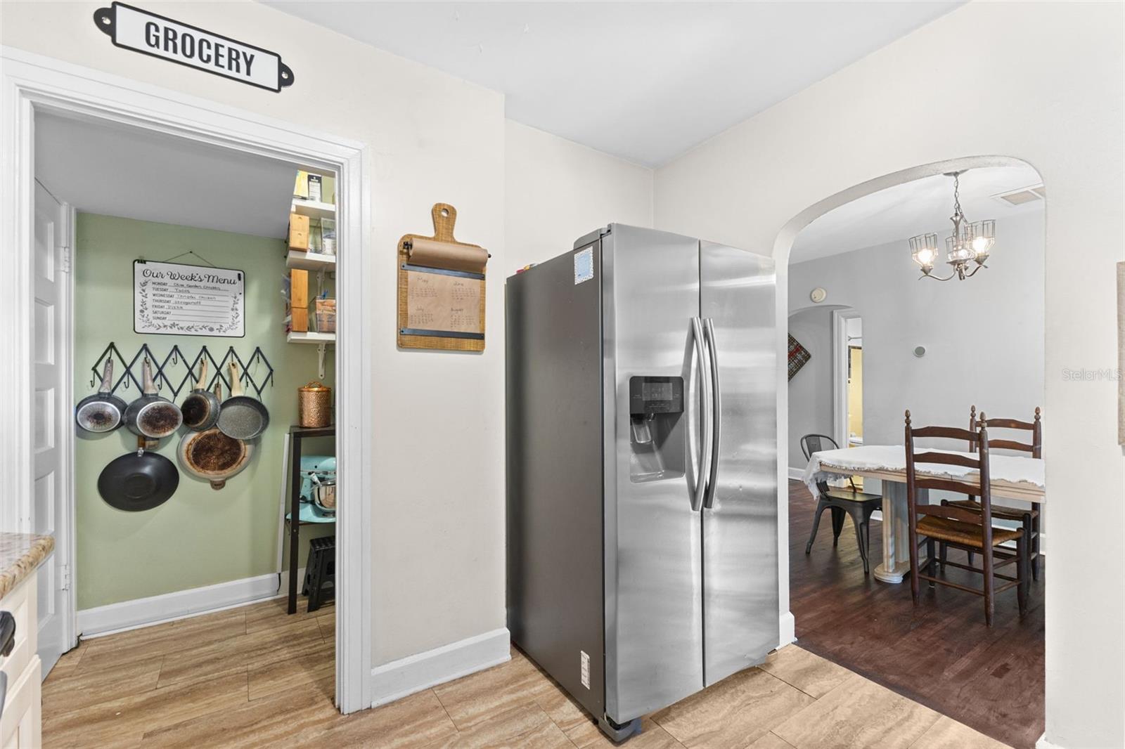 Functional kitchen with stainless appliances, a walk-in pantry, and an open flow into the dining room.