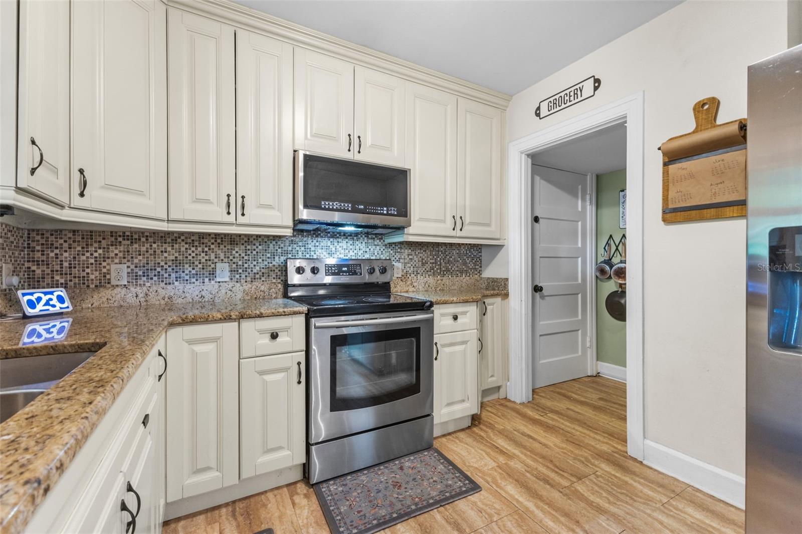 Functional kitchen with stainless appliances, a walk-in pantry, and an open flow into the dining room.