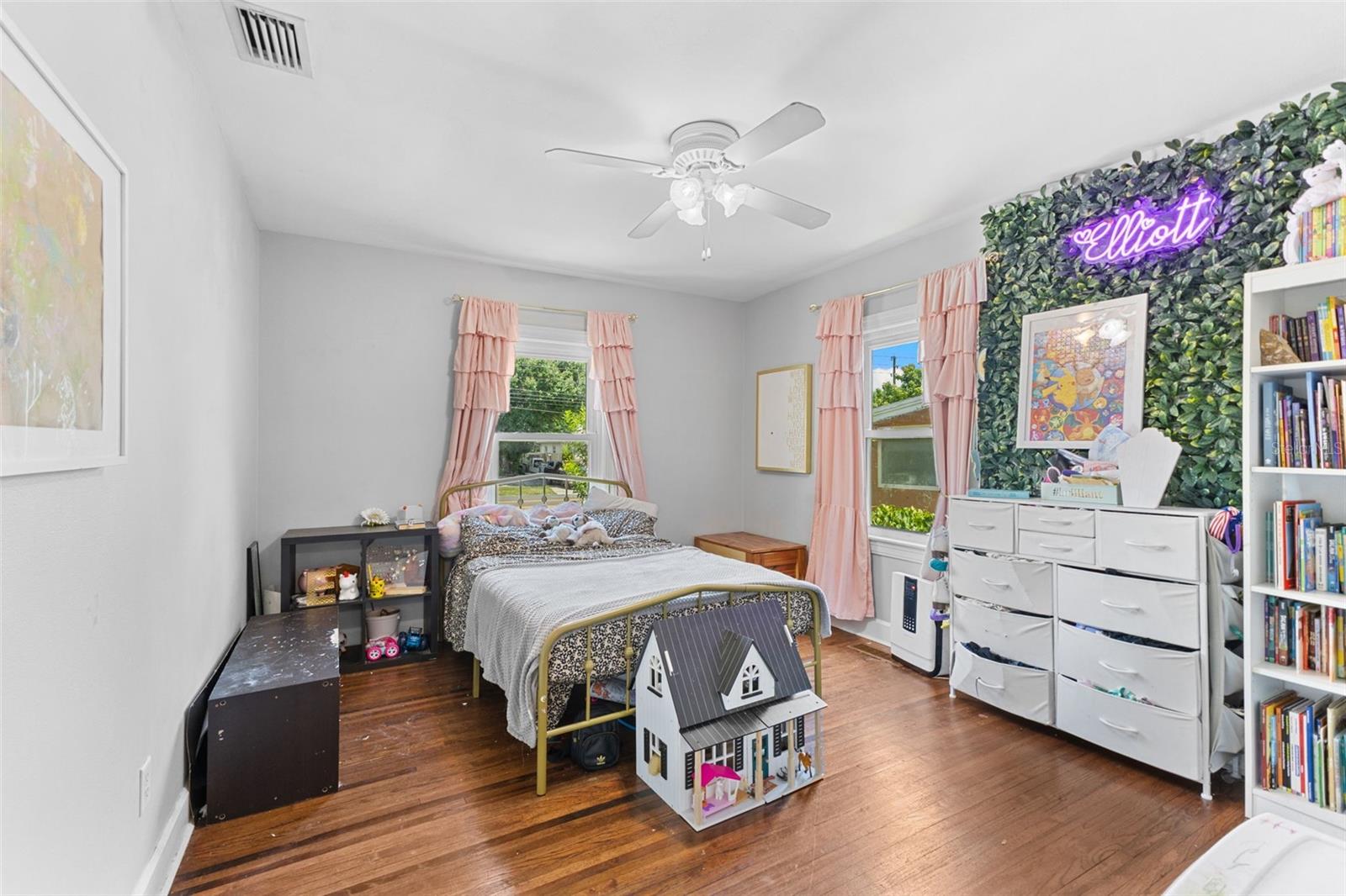 Sunny third bedroom with hardwood floors, dual windows, and plenty of space for rest or play.